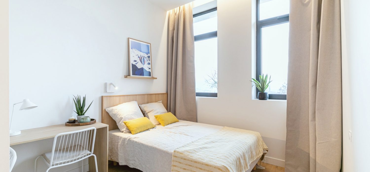 Chambre aménagée avec un lit double en coliving à Grenoble